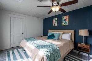 een slaapkamer met een bed met blauwe muren en een plafondventilator bij Bluff City Luxe in Memphis