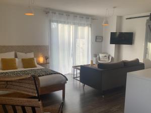 a bedroom with a bed and a desk and a couch at Casa Cosy in Lesneven +16 photos