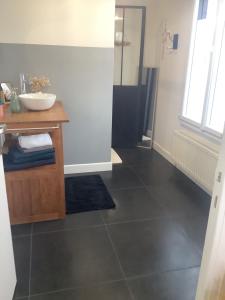 a bathroom with a black tile floor and a sink at Casa Cosy in Lesneven