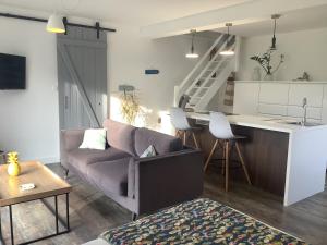 a living room with a couch and a kitchen at Casa Cosy in Lesneven