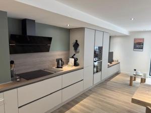 eine Küche mit weißen Schränken und einer Arbeitsplatte in der Unterkunft Nouveau T3 RDC 100m du parc in Brides-les-Bains