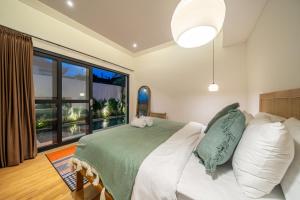a bedroom with a bed and a large window at Lecatica - Brand New 2BDR Paradise Villa with Expansive Pool - Your Dream Retreat in Canggu! in Seminyak
