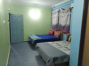 a small room with two beds and a door at Motel Tepoh in Kuala Terengganu