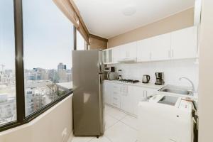 cocina con nevera y ventana grande en GRM1601 Modern 1 BDR with skyline views from Miraflores, en Lima