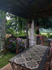 a table and chairs on a porch with flowers at la maison d'Anna chambres d hôtes in Ganac