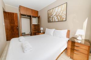 1 dormitorio con 1 cama blanca grande y armario de cristal en GRM1601 Modern 1 BDR with skyline views from Miraflores, en Lima