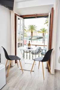 a living room with a table and chairs and a balcony at Taah Billa Guest House in Tavira