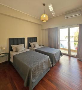 une chambre avec deux lits et une grande fenêtre dans l'établissement Agora Apt2, Metro Station, 2 bdrms, 4 pers by MPS, à Athènes
