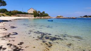 a beach with a house in the water at Casa Cosy in Lesneven