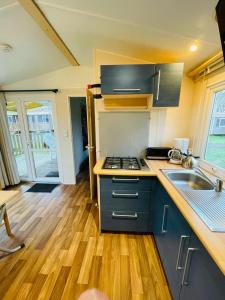 a kitchen with a sink and a stove top oven at Loggia ConfortPlus 2ch 5per Puy duFou 900PA in La Boissière-de-Montaigu