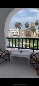 a view of a balcony with a bench and palm trees at Bungalow avec une vue panoramique in Sousse