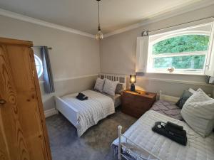 ein Schlafzimmer mit zwei Betten und einem Fenster in der Unterkunft The Porthole in Holmfirth
