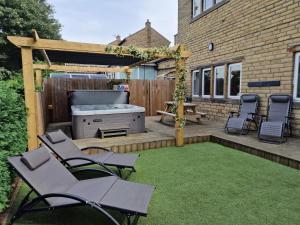 einen Hinterhof mit einem Grill und Stühlen auf einer Terrasse in der Unterkunft The Porthole in Holmfirth