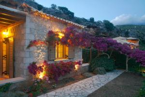 a house with flowers on the side of it at Kripia Holiday Villas in Kardamyli