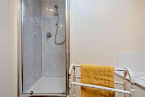 a bathroom with a shower with a yellow towel at Castle Forge 4-Bedroom Historic Purbeck Forge in Kingston, Corfe Castle, Sleeps 7 in Kingston +47 photos