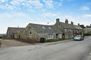 a car parked in front of a stone house at Castle Forge 4-Bedroom Historic Purbeck Forge in Kingston, Corfe Castle, Sleeps 7 in Kingston