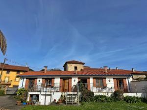 a large white house with a red roof at La Casita Azul - 1003 in Arnuero