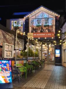 a restaurant with green tables and chairs at night at Heart of Bowness in Bowness-on-Windermere