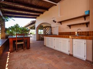 a kitchen with white cabinets and a table at Centro Servizi Marinella in Marinella
