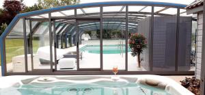 a pool house with a hot tub in the backyard at Les Papillons in Gresswiller