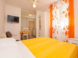 a bedroom with a large bed with a yellow blanket at Apartments Matija in Vodice