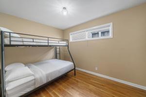 a bedroom with two bunk beds and a window at Perfect Group Stay 7 Beds Gaming NYC Minutes in Bayonne
