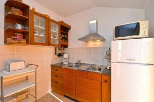 a kitchen with a white refrigerator and a microwave at Apartment Pia Murter in Murter +9 photos
