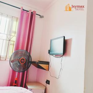 Una televisión o centro de entretenimiento en Jeymax Hotel and Suite
