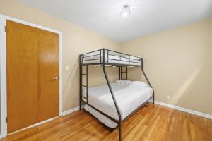 a bedroom with a bunk bed and a wooden floor at 7 Bed Haven Sleeps 12 20Min to NYC Massage Chair in Bayonne