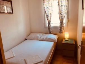 ein kleines Bett in einem Zimmer mit Fenster in der Unterkunft Apartments Marijana Zaboric in Zaboric + 8 Fotos