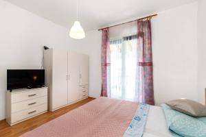 a bedroom with a bed and a tv and a window at Apartment Lara in Tribunj +10 photos