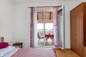 a bedroom with a bed and a view of a table at Apartment Lara in Tribunj