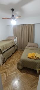 ein Schlafzimmer mit zwei Betten und einem Deckenventilator in der Unterkunft Rosario JCM in Rosario + 4 Fotos