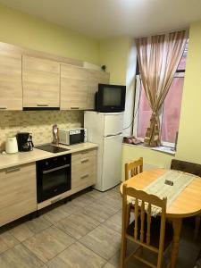 a kitchen with a table and a refrigerator and a microwave at СТОНЕЛ in Veliko Tŭrnovo