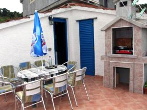 a patio with a table and chairs and a fireplace at Holiday House Serov in Tisno