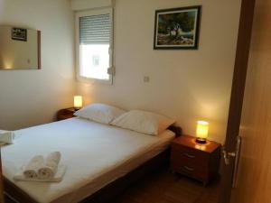 ein Schlafzimmer mit einem Bett mit zwei Handtüchern darauf in der Unterkunft Apartments Marijana Zaboric in Zaboric