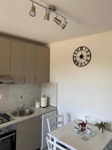 a kitchen with a sink and a clock on the wall at Rural Apartment Ante in Drniš