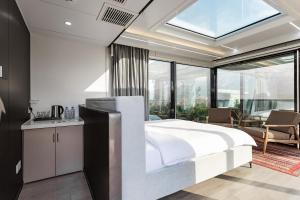 a bedroom with a white bed and a large window at Zvezdnaya Eco-Hotel in Almaty