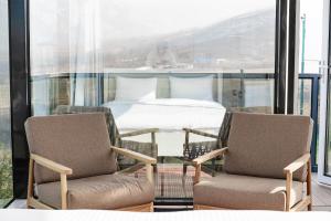 two chairs and a table in a room with a bed at Zvezdnaya Eco-Hotel in Almaty