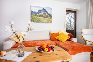 a bedroom with a bed with a bowl of fruit on a table at Haus Bergliebe - Breitenbergblick in Pfronten +21 photos