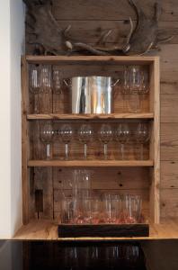 a shelf filled with wine glasses on a wall at Silverbirch Chalet - Davos in Davos +25 photos