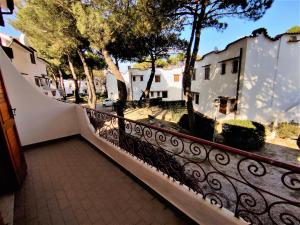 a black fence next to a street with buildings at RESIDENCE El Patio C-4 in Rosolina Mare