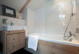 a bathroom with a bath tub and a sink at Silverbirch Chalet - Davos in Davos