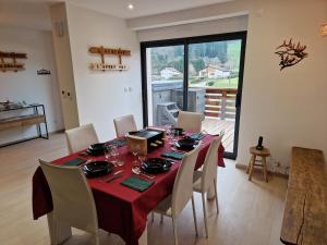 una sala da pranzo con un tavolo con una tovaglia rossa di Gite spa atypique, Vosges, chez Bubu, école rénovée bain nordique et nature a Vecoux