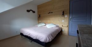 una camera con un letto e una porta blu di Gite spa atypique, Vosges, chez Bubu, école rénovée bain nordique et nature a Vecoux