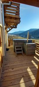 una terrazza in legno con panca e tavolo di Gite spa atypique, Vosges, chez Bubu, école rénovée bain nordique et nature a Vecoux