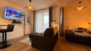een woonkamer met een bank en een tv bij Le Roi du Lac - Disneyland Paris in Lognes