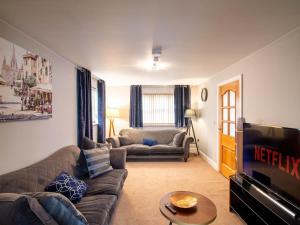 a living room with a couch and a television at Exclusive 3-Bedroom Villa in Sheffield in Sheffield