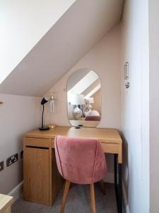 a desk with a pink chair and a mirror at Exclusive 3-Bedroom Villa in Sheffield in Sheffield