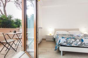 a bedroom with a bed and a balcony with a table at Alloggio turistico a casa di Paoletto in Fiumicino